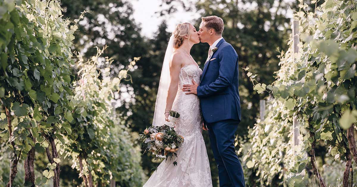 Wes Tessa Lovingston Winery wedding couple in vineyard landscape kiss