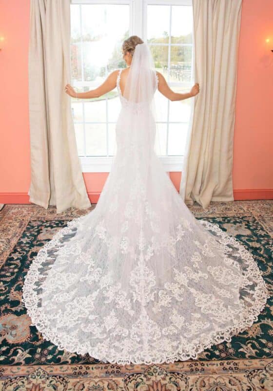 Bride in wedding dress with lace train, scoop back and wedding veil at Williamsburg Winery.