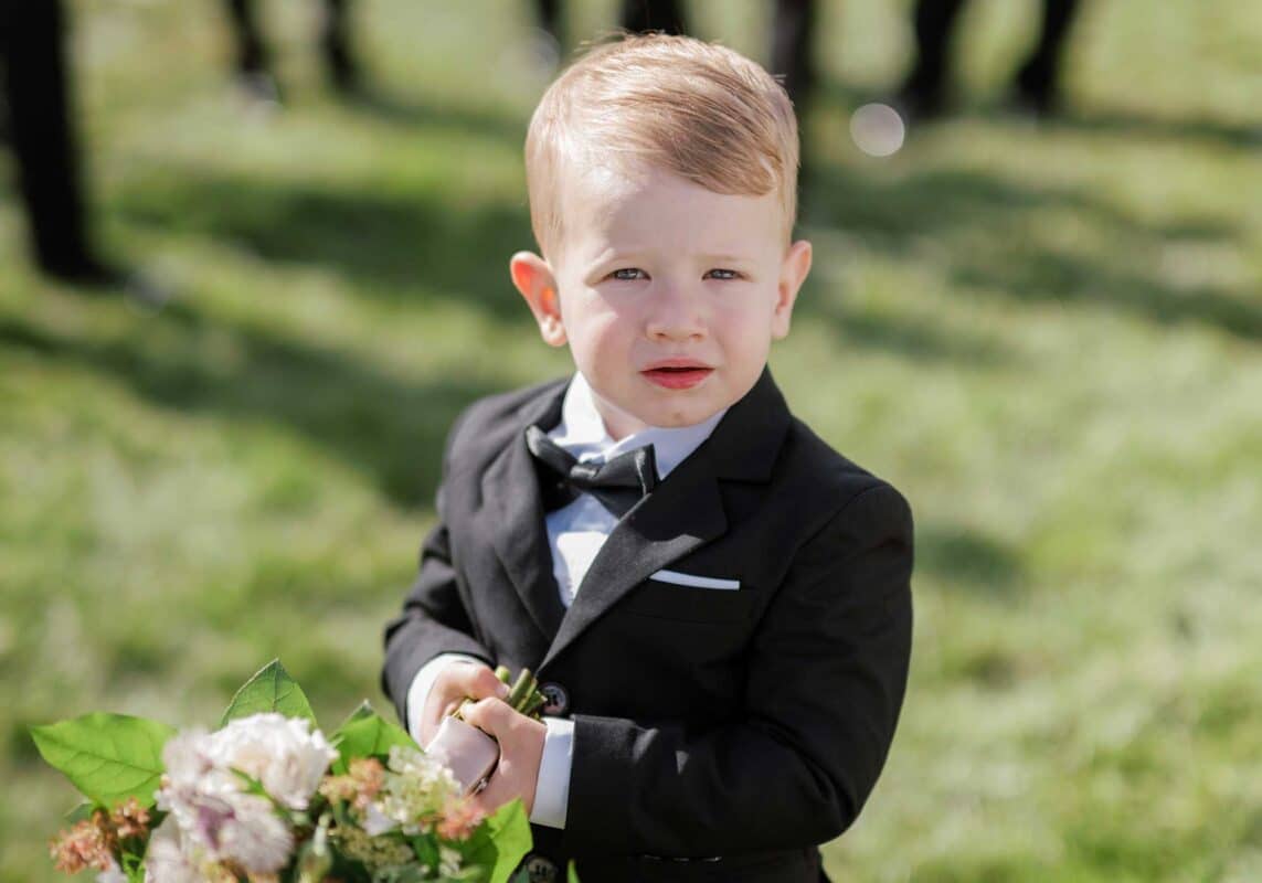 flower boy for wedding wearing black suit