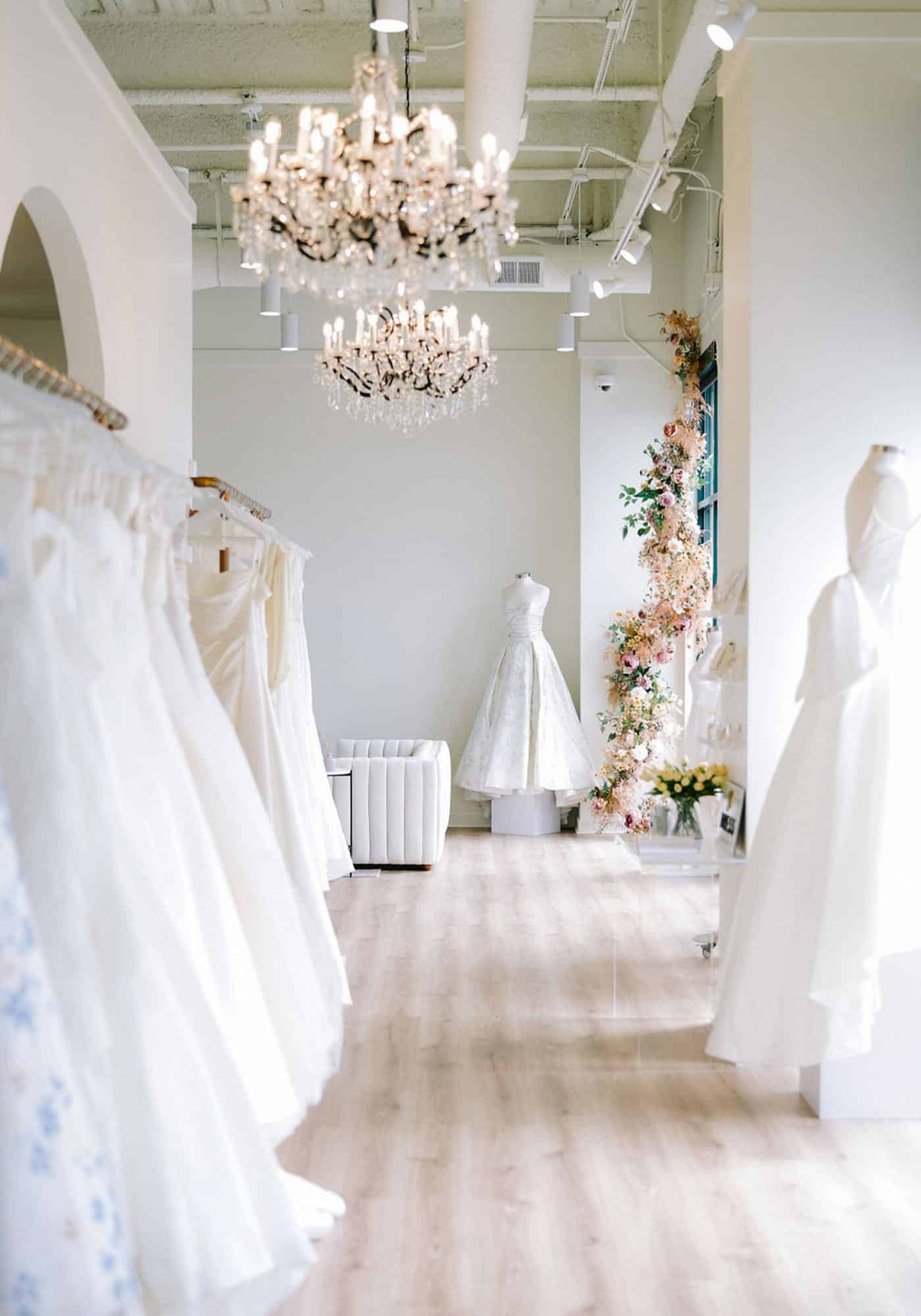 Light filled studio with chandeliers displaying gowns at Annalise Bridal in Virginia