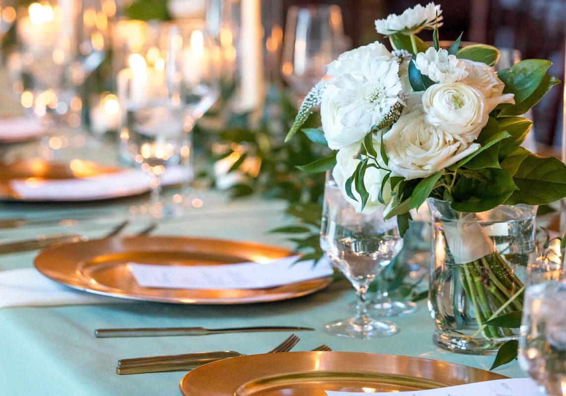tablescape closeup of white roses, gold plates