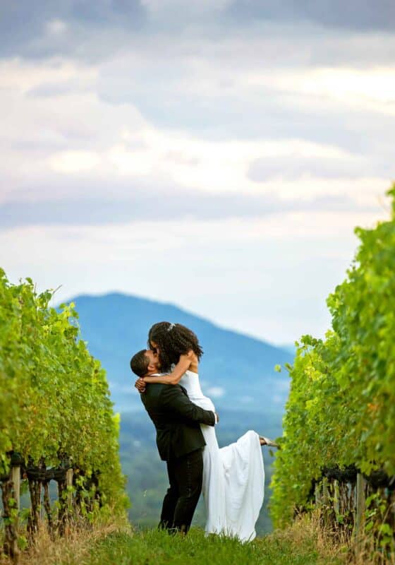 black bride and groom kissing in vineyards at Veritas