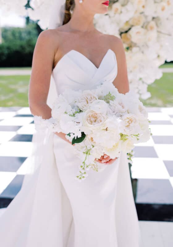 strapless bridal gown with plunging sweetheart neckline and all white wedding bouquet
