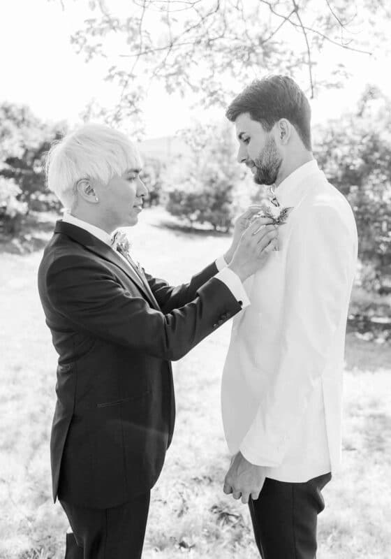 Groom fastens partner's boutonniere, Summer Wedding at the Market at Grelen, Image @ Morgan Lee Photography